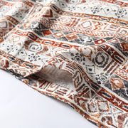 Close-up of patterned fabric with brown, black, and white design on a white background