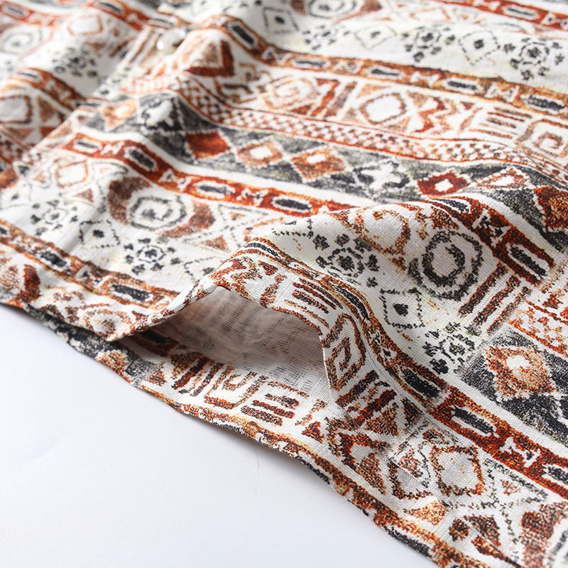 Close-up of patterned fabric with brown, black, and white design on a white background