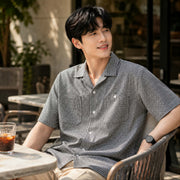 Young man wearing a black and white check short sleeve shirt 