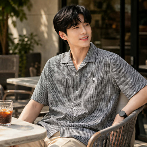 Young man wearing a black and white check short sleeve shirt 