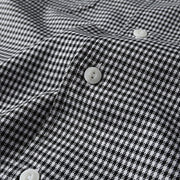 Close-up of button closure and micro check fabric texture on men’s Cuban collar shirt
