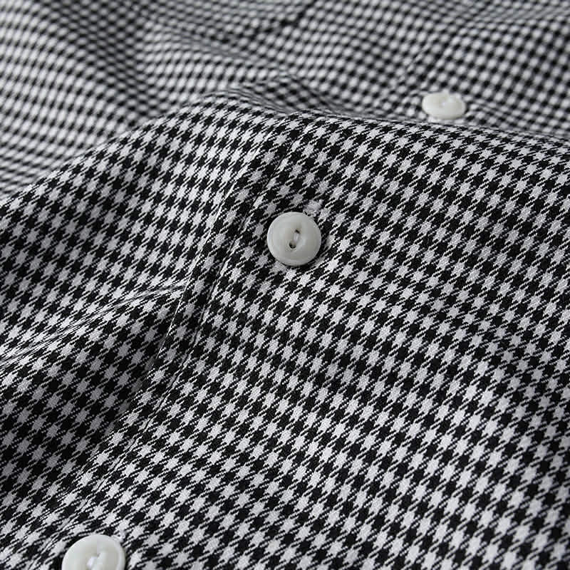 Close-up of button closure and micro check fabric texture on men’s Cuban collar shirt

