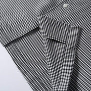 Hem detail of black en white houndstooth cuban collar shirt