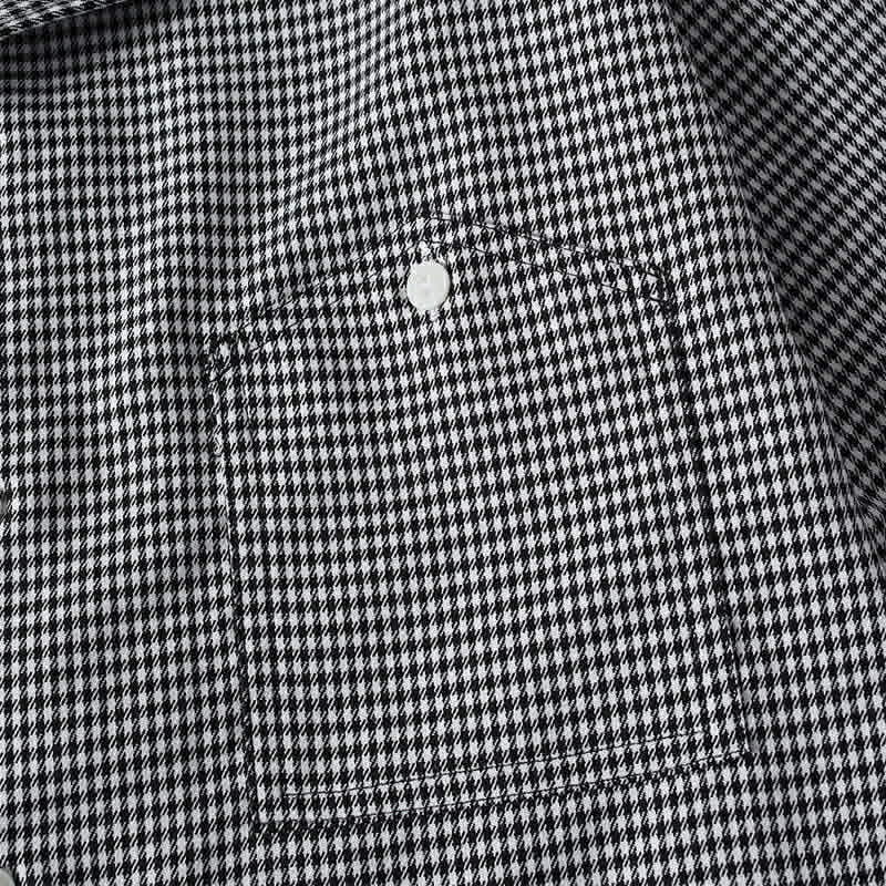 Close-up of chest pocket stitching and micro check fabric pattern on casual men’s shirt
