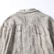 Rear fabric detail of men’s paisley print Cuban collar shirt showing pattern and stitching.
