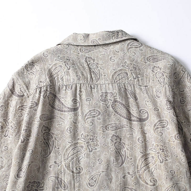 Rear fabric detail of men’s paisley print Cuban collar shirt showing pattern and stitching.
