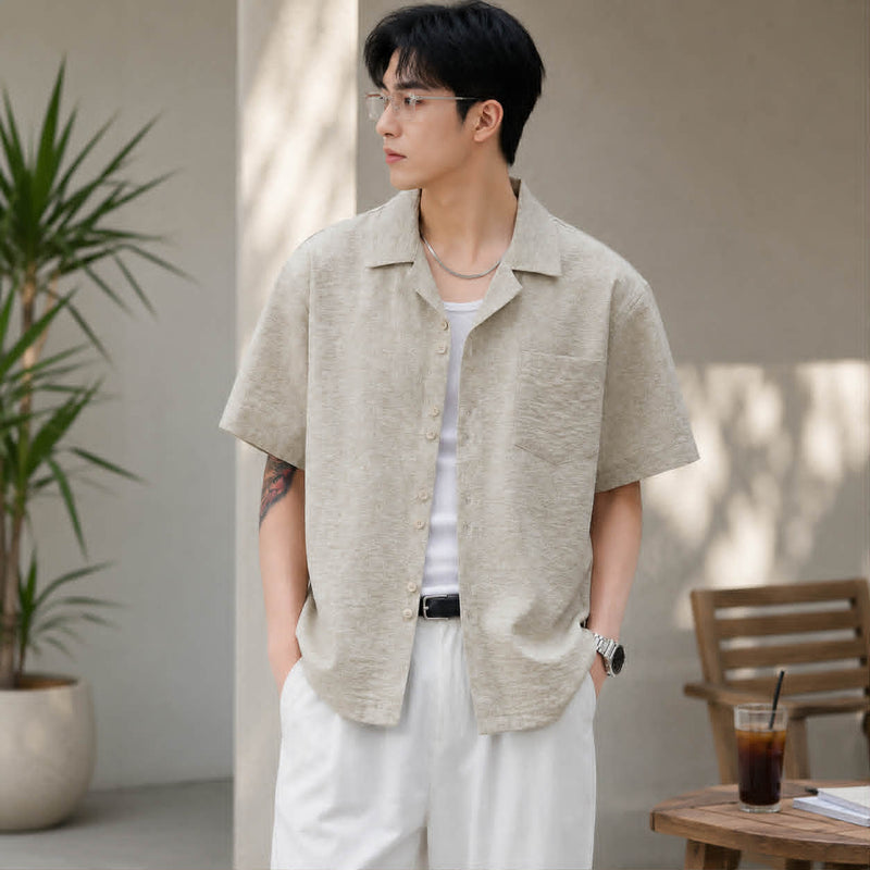 Man wearing apricot textured Cuban collar short sleeve shirt in a casual summer lifestyle setting.
