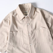Beige button-up shirt collar and pocket detail
