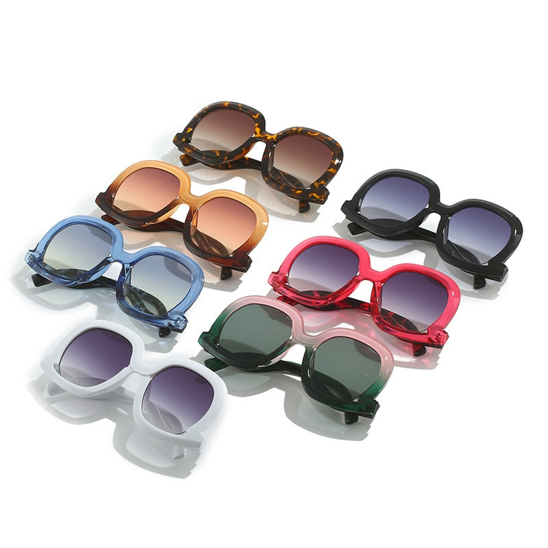 Oversized oval sunglasses collection featuring black, leopard, red, champagne brown, pink green, blue leopard, and white color options.
