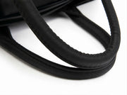 Close-up of soft padded carry handles on a lightweight winter puffer tote bag.
