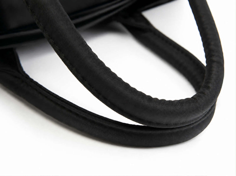 Close-up of soft padded carry handles on a lightweight winter puffer tote bag.
