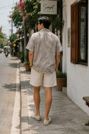 Man wearing a paisley Cuban collar shirt walking on a street showing the back view of the shirt
