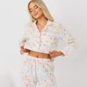 Close-up front view of a women’s pastel floral satin pajama set featuring a button-up long sleeve top.
