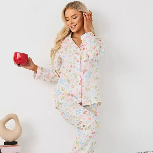 Woman wearing a pastel floral satin pajama set while holding a red mug for a cozy morning look.
