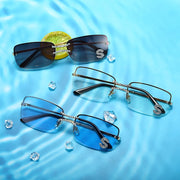 Premium square rimless sunglasses with crystal bridge detail and multiple lens colors on aquatic background
