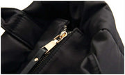 Close-up of premium zipper closure on a black winter puffer tote bag.
