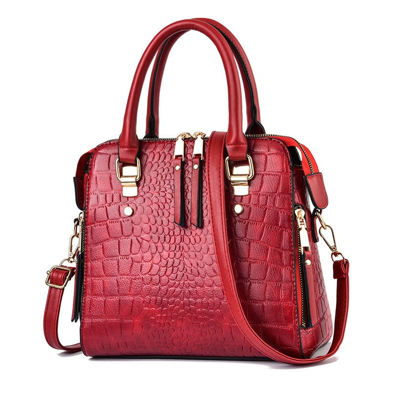 Red crocodile texture handbag with elegant gold hardware and shoulder strap

