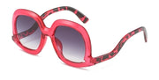 Bold red leopard oval sunglasses with gray gradient lenses and oversized fashion frame for statement summer styling.
