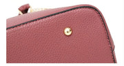  Close-up view of protective metal feet on the bottom of the pink embossed rose handbag