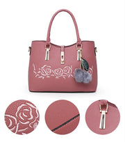  Pink handbag featuring embossed rose floral design, textured leather, and gold-tone hardware