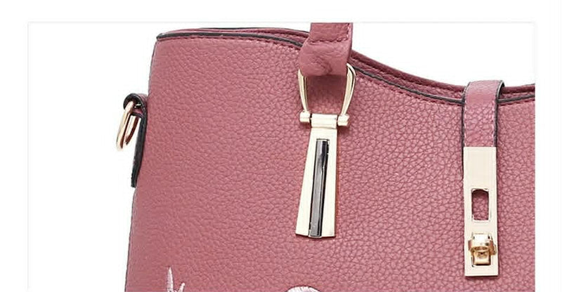  Close-up of premium gold-tone hardware and lock detail on pink embossed rose handbag