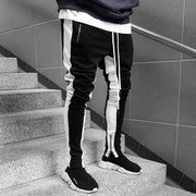Skinny joggers for men showcasing a stylish black and white design on a staircase.