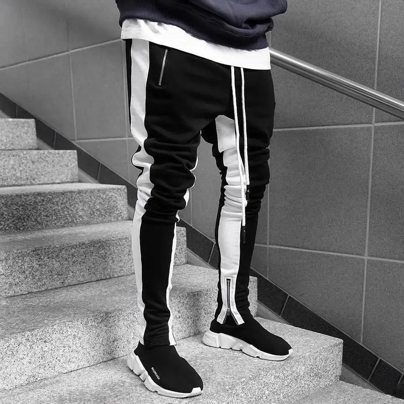 Skinny joggers for men showcasing a stylish black and white design on a staircase.