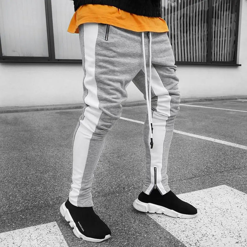 Skinny joggers for men in grey and white with a relaxed fit, styled with black slip-on shoes.