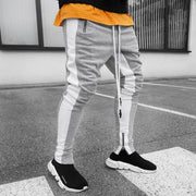 Skinny joggers for men in gray and white, paired with black slip-on shoes, perfect for casual wear.