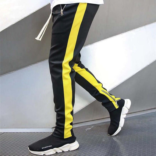 skinny joggers for men featuring black and yellow design, worn with stylish sneakers on a modern backdrop.