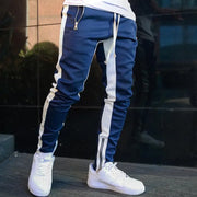 skinny joggers for men in navy with white stripes, styled with white sneakers.