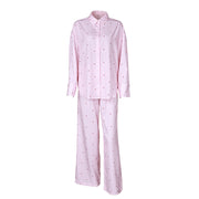 Women’s soft pink long sleeve button-up pajama set with matching full-length pants displayed on a white background.
