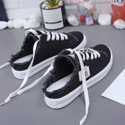 Women’s black canvas lace-up sneakers with comfortable flat rubber sole.
