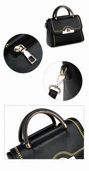 Detailed view of zipper pull, shoulder strap clip, and gold-tone handle on black handbag.
