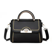 Black structured crossbody handbag with gold-tone handle and decorative stitching.
