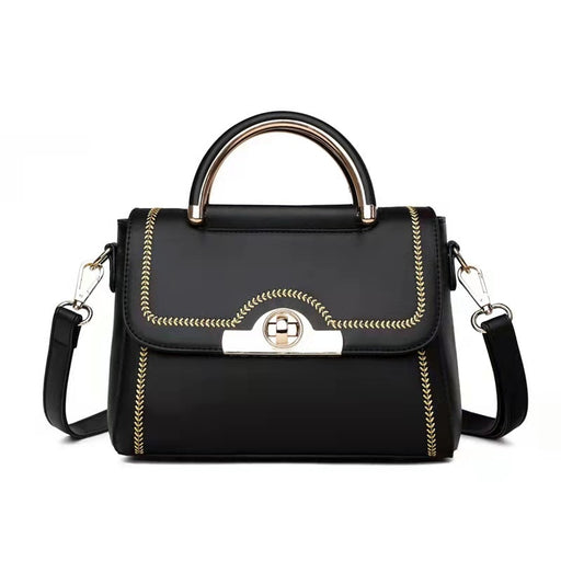 Black structured crossbody handbag with gold-tone handle and decorative stitching.
