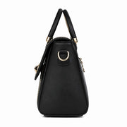 Side profile of black structured crossbody handbag showing its compact shape and metal hardware.

