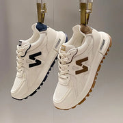 Side view of women’s lightweight athletic sneakers with flexible rubber outsole.
