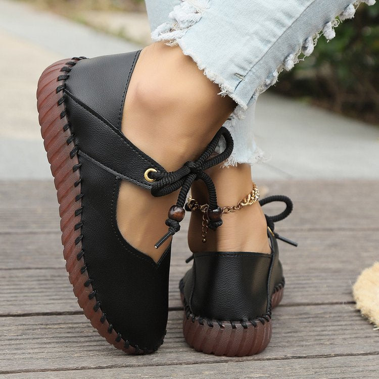 Side view of women’s black casual lace-up sneakers featuring a comfortable flat sole and lace-up closure.

