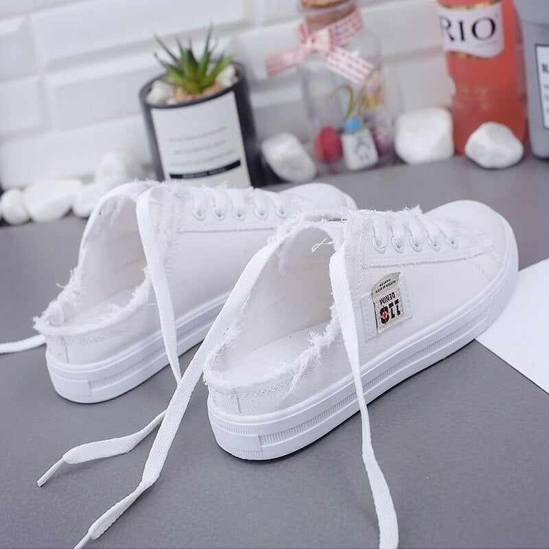 Women’s classic white canvas lace-up sneakers with lightweight low-top casual design.
