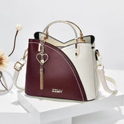 Burgundy and white women's color block handbag with elegant tassel charm and shoulder strap
