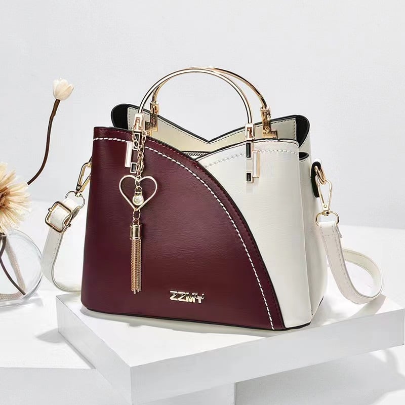 Burgundy and white women's color block handbag with elegant tassel charm and shoulder strap
