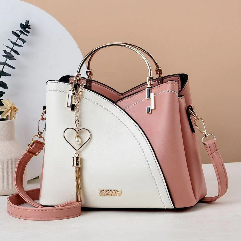 Pink and white women's color block crossbody handbag with elegant gold hardware

