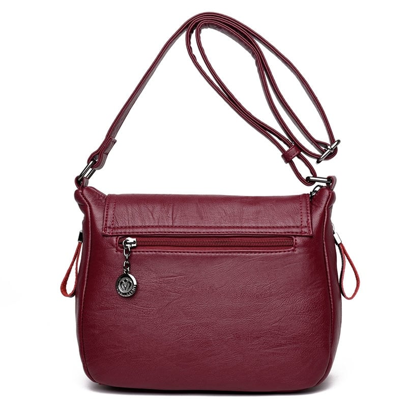 Back view of women's genuine leather crossbody bag in red wine color with zip pocket
