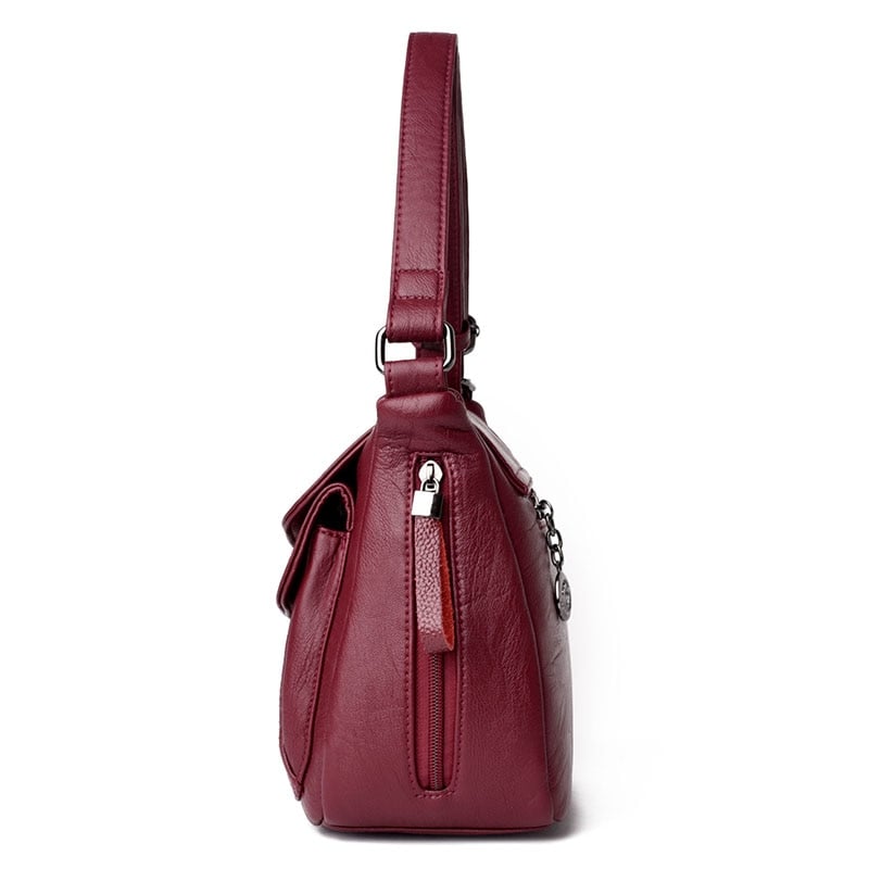 Side view of women's genuine leather crossbody bag in red wine color
