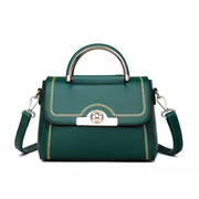 Green structured crossbody handbag with gold-tone handle and decorative stitching.
