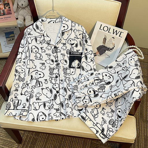 Women's white long sleeve cartoon print pajama set with matching full-length pants displayed on a chair.
