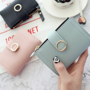 Woman holding a stylish mini PU leather coin purse wallet for everyday use.
