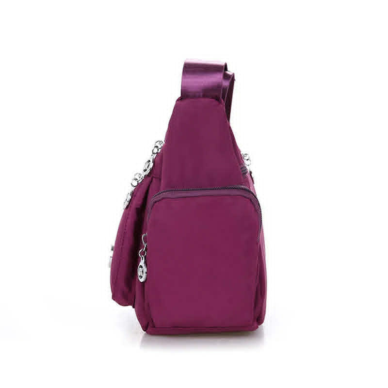 Side profile of women’s purple nylon messenger bag showing side storage pocket
