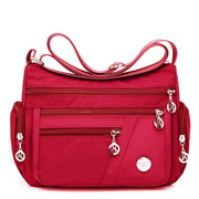 Women’s red nylon crossbody messenger bag with front zipper pockets
